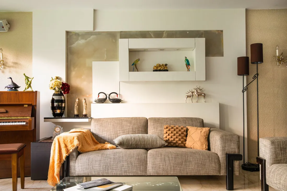 Wohnzimmer mit einem Klavier an der Wand neben Sofa und Beistelltisch